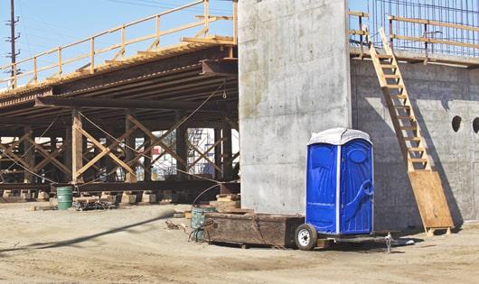 row of portable restrooms on a busy work site